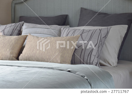 Pillows with on the bed with light blue blanket 27711767