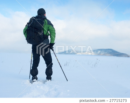 Man with snowshoes take a rest in snow. Man with snowshoes take a rest in snow. 27715273