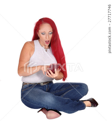 Woman sitting on floor with cellphone. 27717746