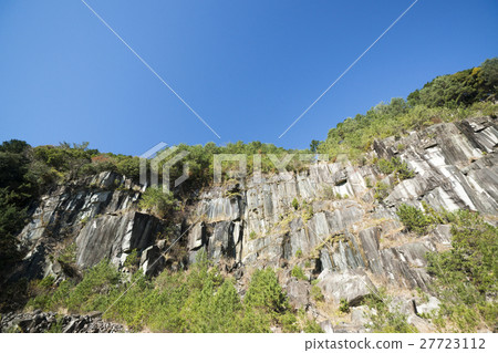 Rocky mountain of columnar joints rising in blue sky bag Rocky mountain of columnar joints rising in blue sky bag 27723112