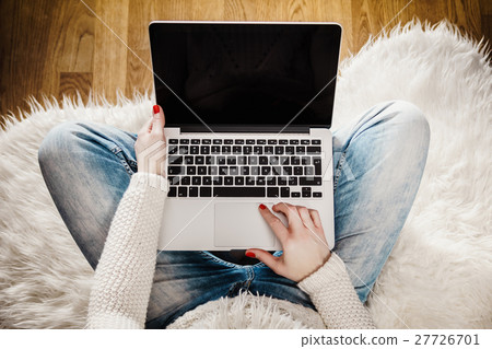 woman holding a computer on her lap woman holding a computer on her lap 27726701