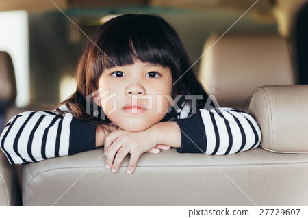 Little girl showing her unhappy face in car Little girl showing her unhappy face in car 27729607
