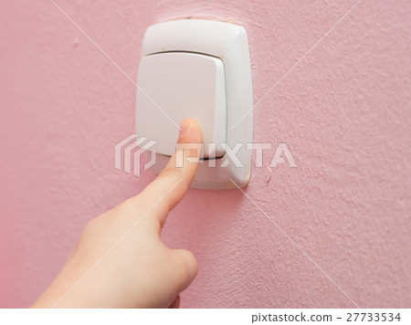 Child's hand finger presses the switch, close-up 27733534