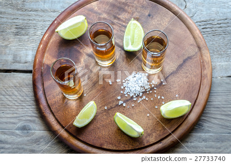 Glasses of tequila on the wooden board 27733740