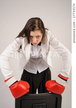 Young angry businesswoman in boxing gloves Young angry businesswoman in boxing gloves 27734574