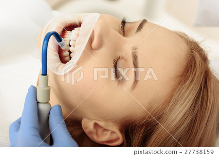 Stomatologist putting saliva aspirator in oral 27738159