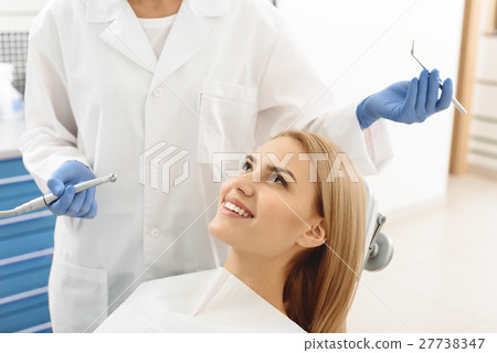 Odontologist beginning operation of female teeth 27738347