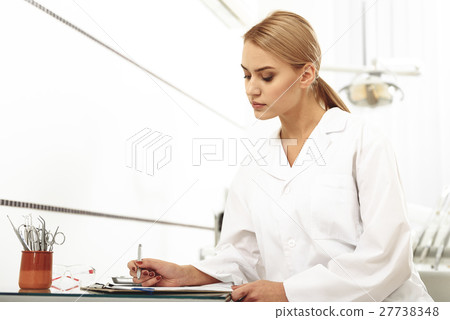 Odontologist filling up a form in office 27738348