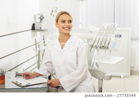 Cute glad stomatologist sitting in dental office 27738349