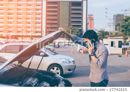 Young asian handsome man standing by the Broken Down car Young asian handsome man standing by the Broken Down car 27742810