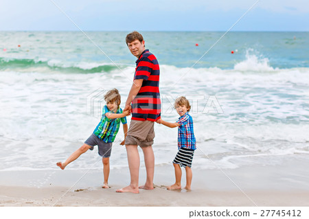 Two little kids boys and father on the beach of Two little kids boys and father on the beach of 27745412