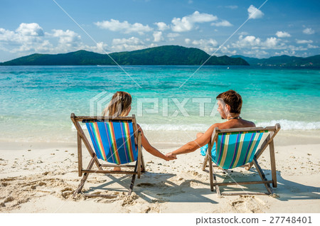 Couple in loungers on a beach at Thailand Couple in loungers on a beach at Thailand 27748401