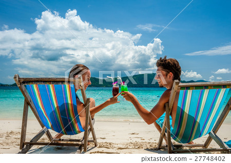 Couple in loungers on a beach at Thailand Couple in loungers on a beach at Thailand 27748402