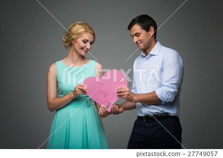 Beautiful couple holding pink broken heart Beautiful couple holding pink broken heart 27749057