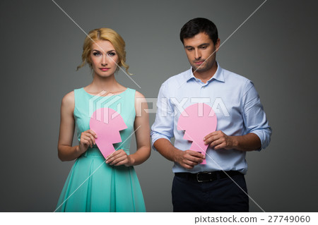 Beautiful couple holding pink broken heart Beautiful couple holding pink broken heart 27749060