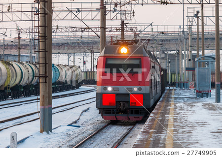 Electric train passing a platform at the station 27749905