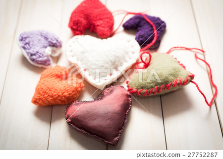 Colorful knitted hearts on light, wooden boards 27752287