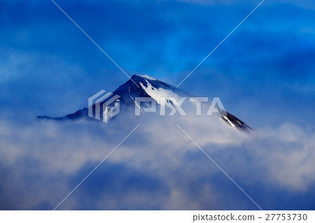 Dark winter mountain with snow in the clouds Dark winter mountain with snow in the clouds 27753730