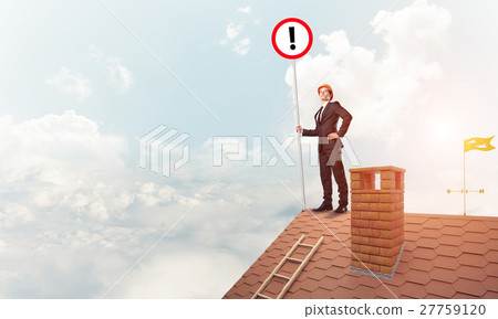 Businessman on house top showing sign with exclamation mark. Mix 27759120