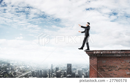 Danger and risk concept with businessman making step from edge 27760578
