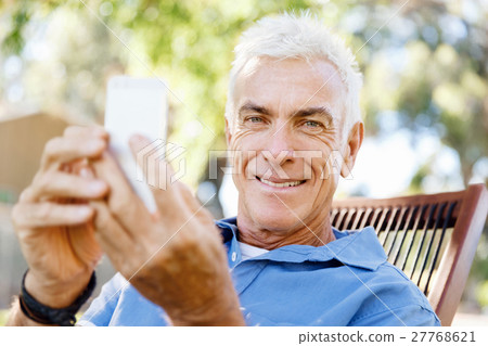 LoMature man outdoors using mobile phone LoMature man outdoors using mobile phone 27768621