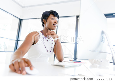 Portrait of businesswoman working at her desk in office 27770045