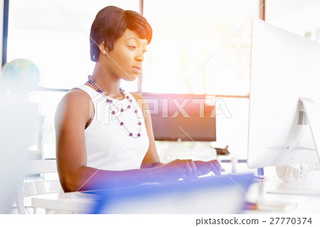 Portrait of businesswoman working at her desk in office 27770374