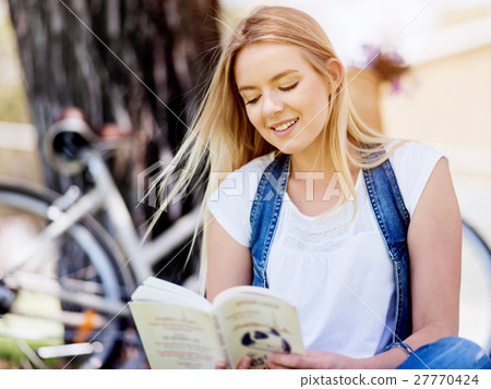 Young woman reading a book in park 27770424