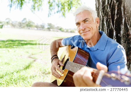 Senior man plying guitar outdoors Senior man plying guitar outdoors 27770445