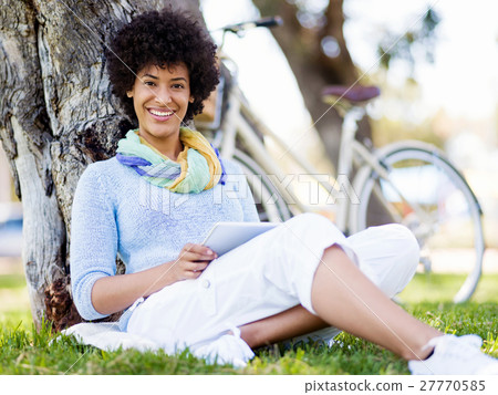 Young woman using tablet in the park. Young woman using tablet in the park. 27770585