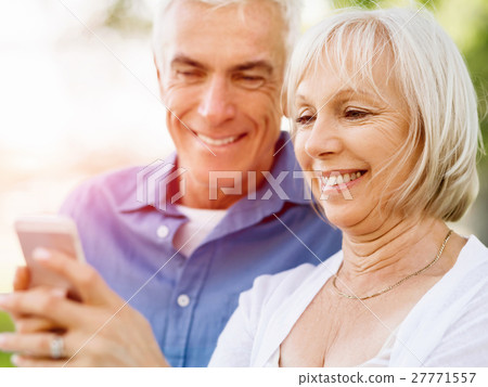 Happy senior couple looking at smartphone Happy senior couple looking at smartphone 27771557