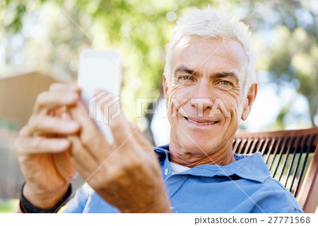 LoMature man outdoors using mobile phone 27771568