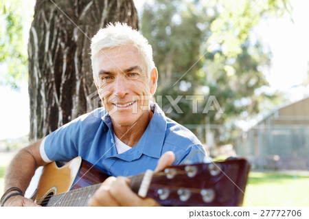 Senior man plying guitar outdoors 27772706