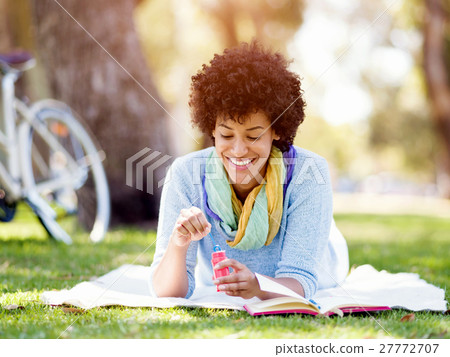 Beautiful woman blowing bubbles in park Beautiful woman blowing bubbles in park 27772707