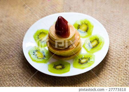 Pancakes with strawberry cream and kiwi fruit 27773818