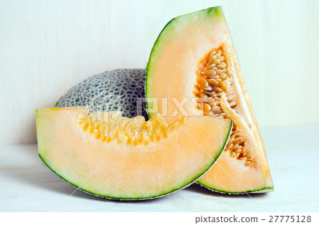 Cucumis melo or melon with half and seeds on wood 27775128