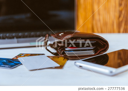 laptop wallet glasses phone on table 27777536