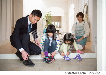 A young father and a sister of elementary school students wearing shoes at the entrance 27778213