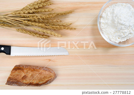 Flour and wheat in a glass bowl and chopping board 27778812