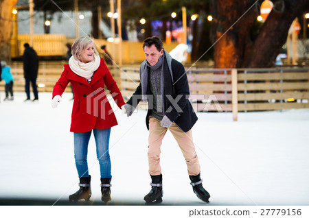 Beautiful senior couple ice skating in city centre Beautiful senior couple ice skating in city centre 27779156