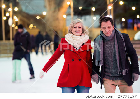 Beautiful senior couple ice skating in city centre Beautiful senior couple ice skating in city centre 27779157