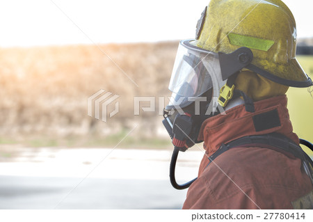single fireman in fire fighting protection suit 27780414