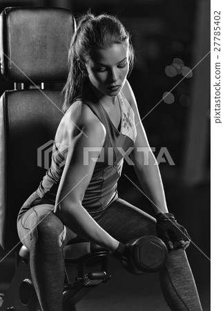 Young woman lifting the dumbbells 27785402