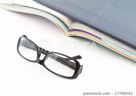 Glasses in front of opened magazines. Glasses in front of opened magazines. 27789581