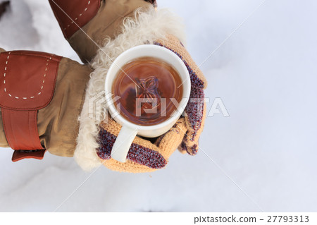Female hands in knitted grey mittens hold white cup of black spi 27793313