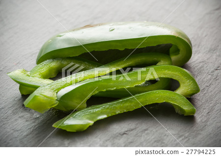 sliced green peppers on chalkboard background 27794225