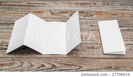Four - fold white template paper on wood texture . 27796658