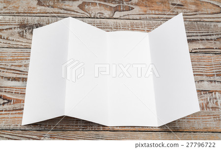 Four - fold white template paper on wood texture . 27796722