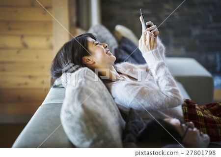 一個操作智能手機的別墅度假女人 一個操作智能手機的別墅度假女人 27801798