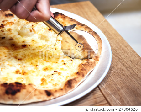 Pizza on wooden board Hand cut with pizza cutter 27804620